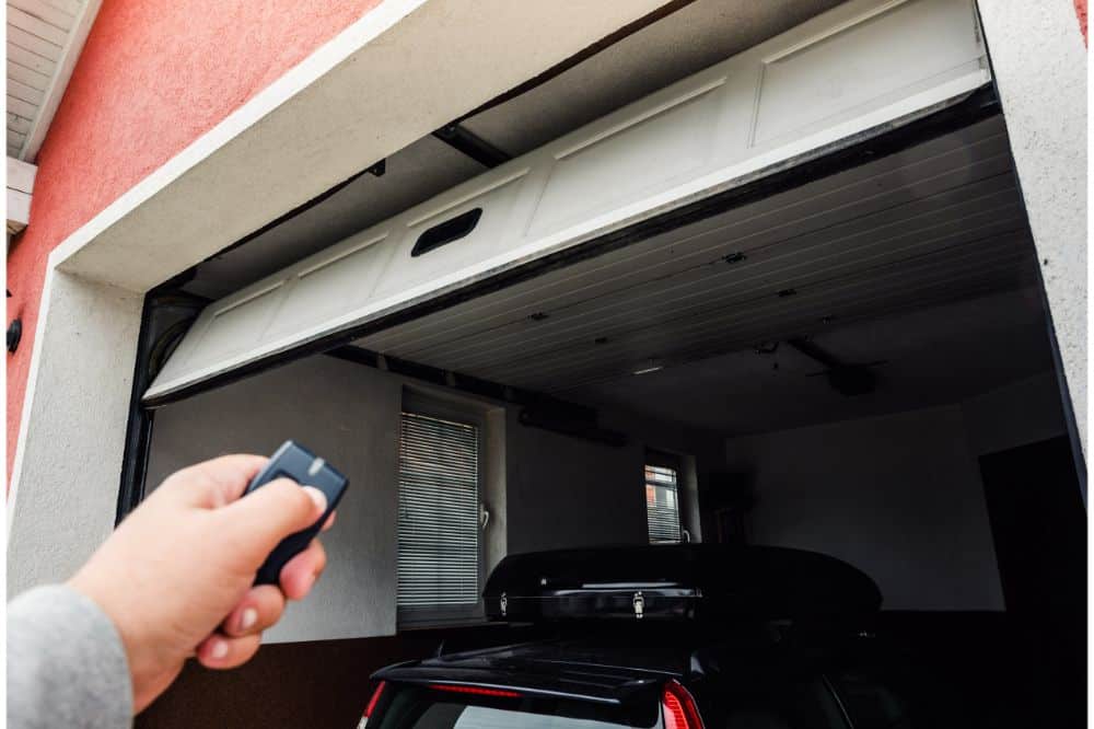 Hand uses remote controller for closing and opening garage door
